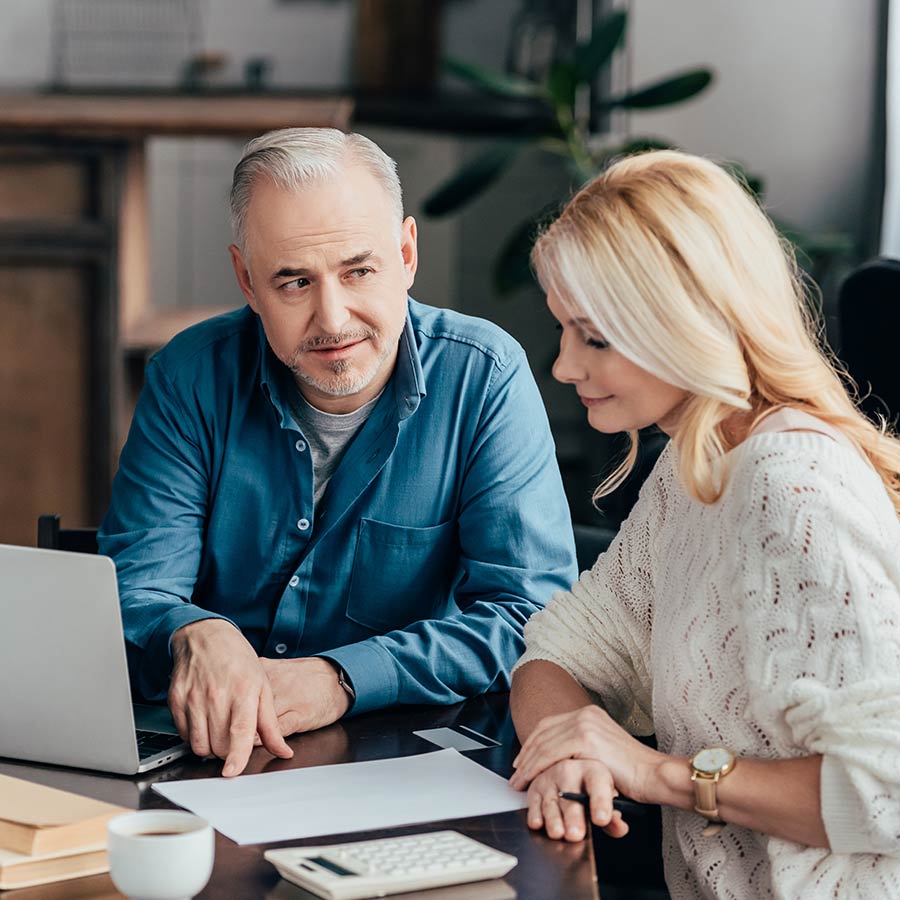 Couple Sitting At Table Reviewing Their Finances