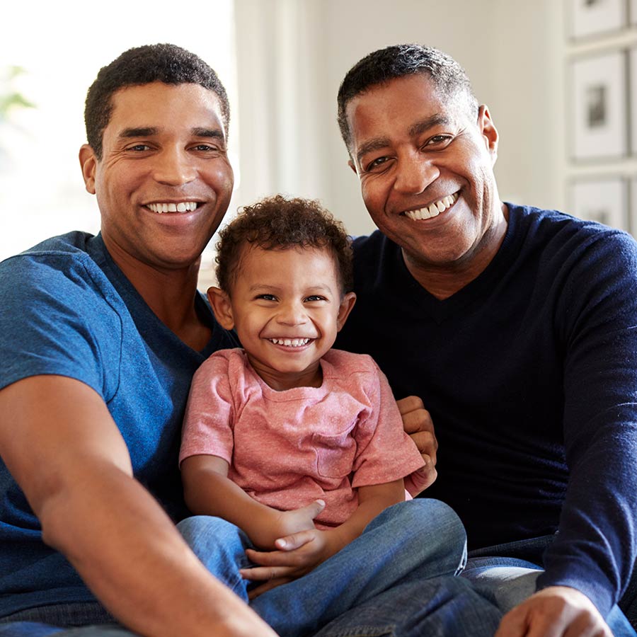 Male Family Group Sitting On A Sofa In The Living Room